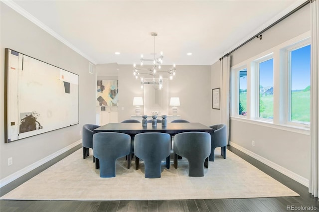 dining area with ornamental molding, a chandelier, and dark wood-type flooring