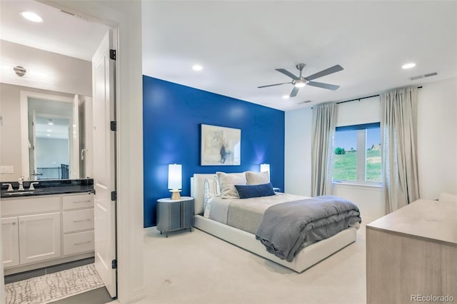 carpeted bedroom with sink and ceiling fan