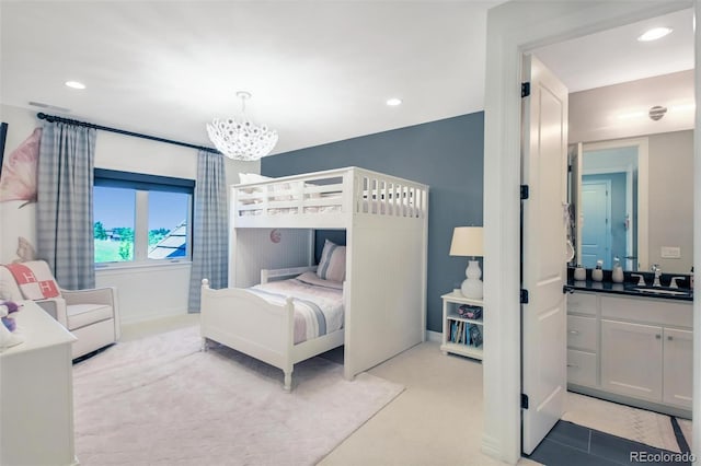 bedroom featuring a notable chandelier, sink, and light colored carpet