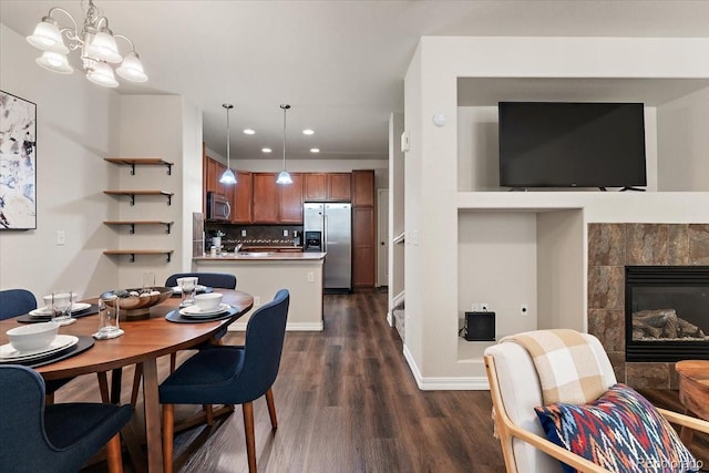dining area featuring baseboards, dark wood-style floors, recessed lighting, a chandelier, and a tiled fireplace