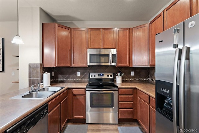 kitchen with brown cabinets, appliances with stainless steel finishes, and a sink