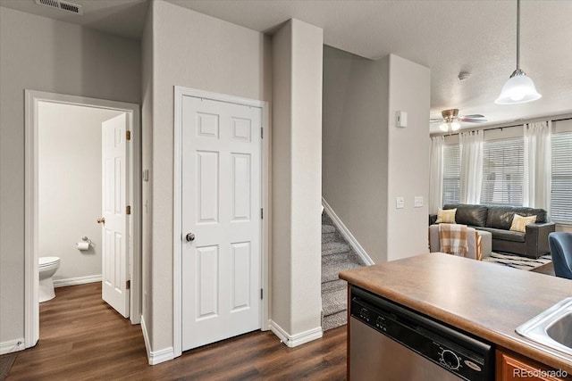 kitchen featuring dark wood-type flooring, baseboards, dishwasher, and decorative light fixtures