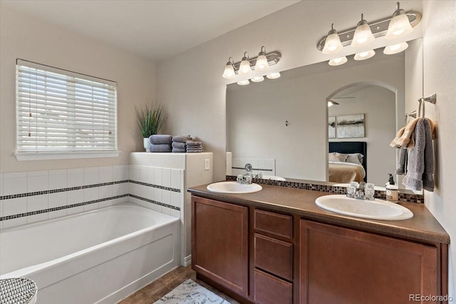 bathroom featuring a sink, a garden tub, ensuite bath, and double vanity
