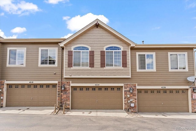 view of property with an attached garage and stone siding