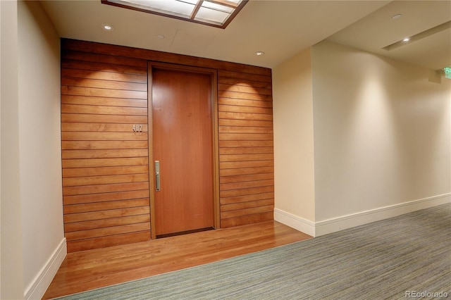 foyer with baseboards, wood finished floors, and recessed lighting