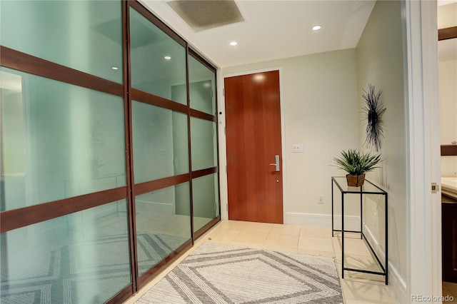 corridor featuring recessed lighting, light tile patterned flooring, and baseboards