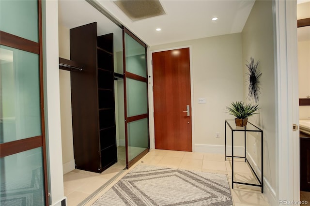 hall featuring light tile patterned floors and recessed lighting