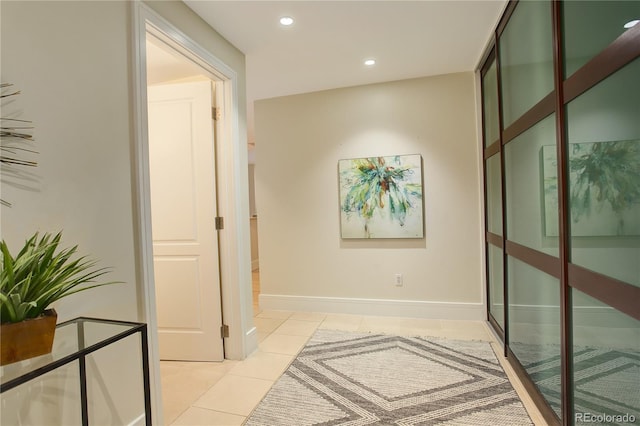 hall featuring light tile patterned floors, recessed lighting, and baseboards