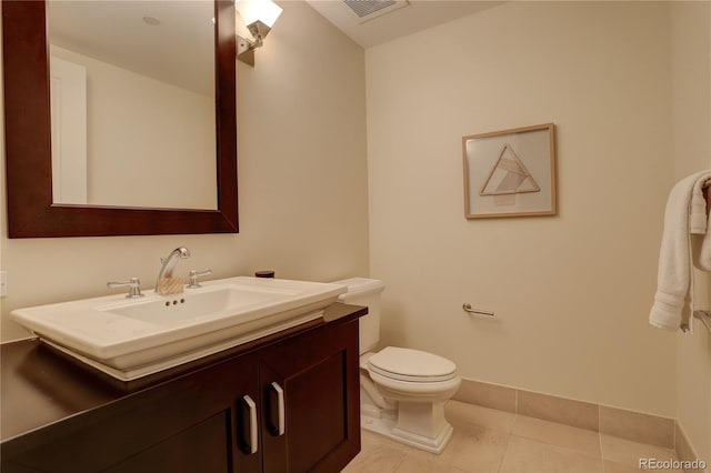 bathroom featuring tile patterned flooring, vanity, toilet, and baseboards
