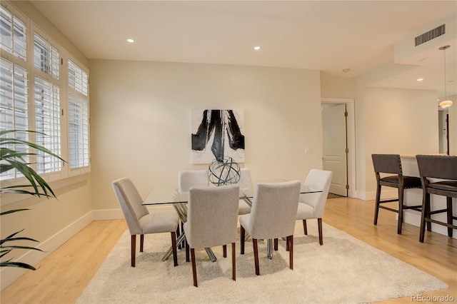 dining space featuring baseboards, light wood-type flooring, and recessed lighting