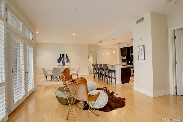 dining area featuring light wood-style flooring, baseboards, and recessed lighting