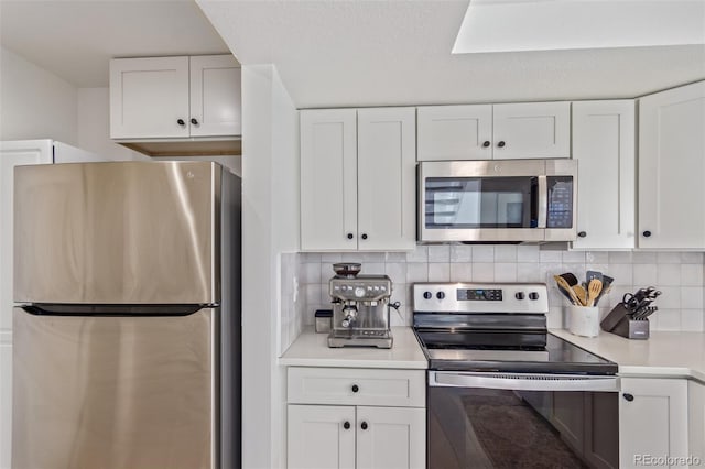 kitchen with backsplash, white cabinetry, and stainless steel appliances