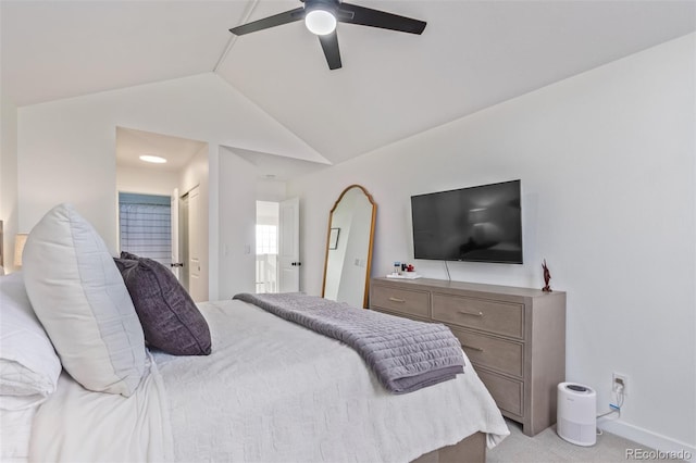 carpeted bedroom featuring ceiling fan, ensuite bathroom, and lofted ceiling