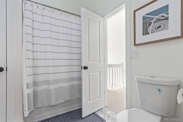 bathroom featuring shower / bath combination with curtain and toilet