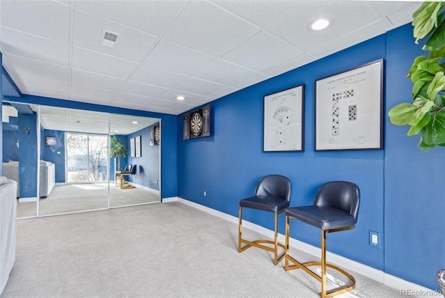 unfurnished room featuring carpet flooring and a drop ceiling