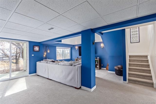 carpeted living room with a paneled ceiling