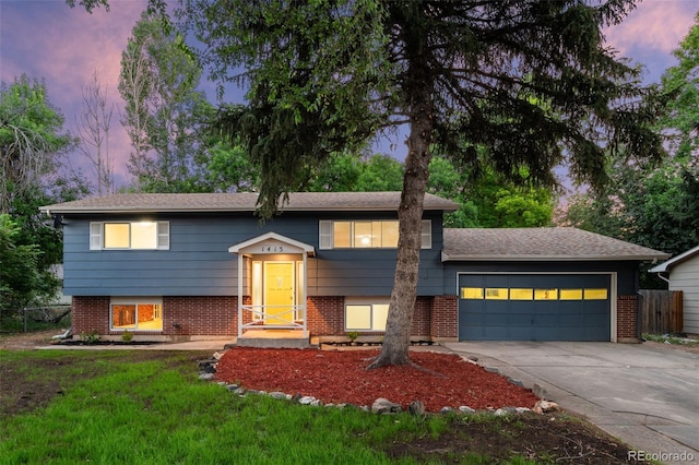 1413 S Bryan Ave, Fort Collins, CO 80521 - raised ranch featuring an attached garage, concrete driveway, and brick siding