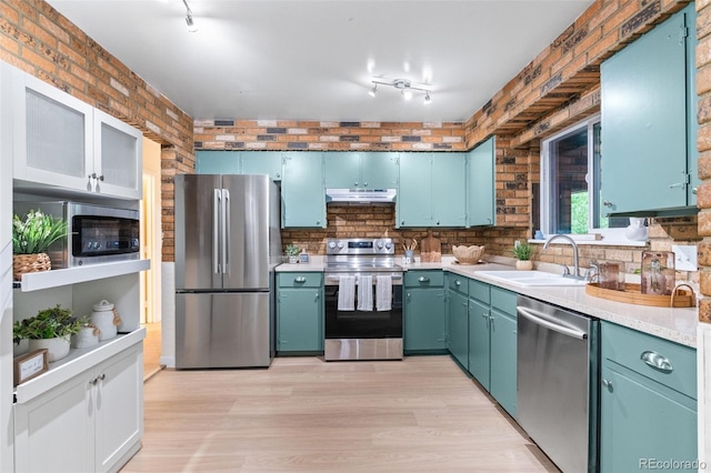 1413 S Bryan Ave, Fort Collins, CO 80521 - kitchen featuring appliances with stainless steel finishes, under cabinet range hood, light countertops, light wood finished floors, and rail lighting