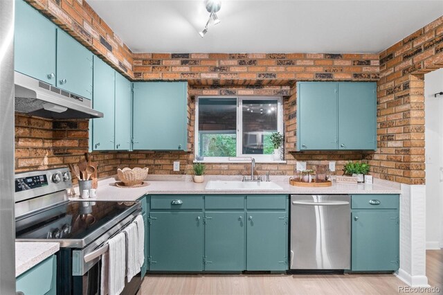 1413 S Bryan Ave, Fort Collins, CO 80521 - kitchen featuring appliances with stainless steel finishes, under cabinet range hood, light countertops, and light wood-style floors