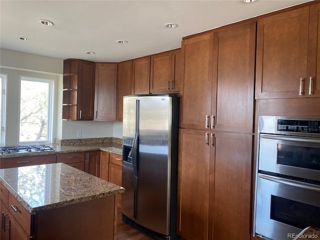 1123 S Quince Way, Denver, CO 80231 - kitchen featuring stainless steel appliances, open shelves, light stone counters, brown cabinets, and recessed lighting