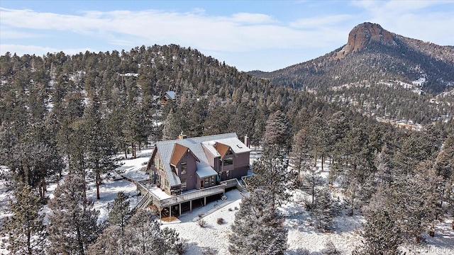 snowy aerial view with a forest view and a mountain view