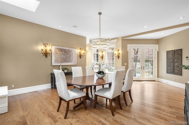 465 Monroe St, Denver, CO 80206 - dining space with light wood finished floors, a chandelier, baseboards, french doors, and a skylight