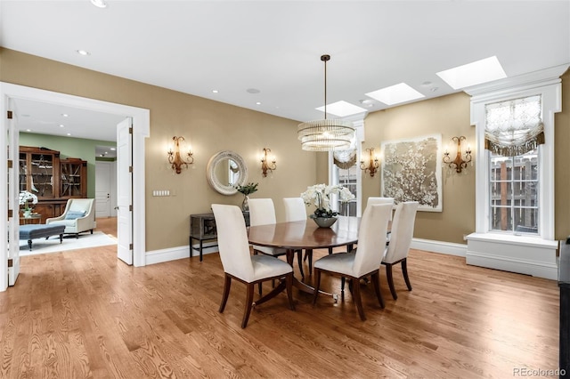 465 Monroe St, Denver, CO 80206 - dining area with a skylight, light wood-style floors, a chandelier, baseboards, and recessed lighting