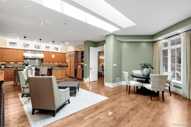465 Monroe St, Denver, CO 80206 - living area with light wood-style flooring, baseboards, a skylight, and recessed lighting
