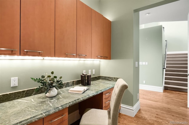 465 Monroe St, Denver, CO 80206 - kitchen featuring light wood-style floors, baseboards, and dark stone countertops