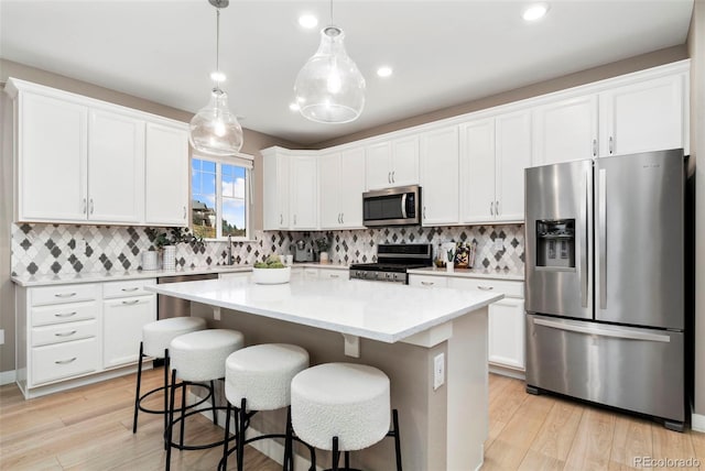 4082 Fortune Ln, Castle Rock, CO 80109 - kitchen featuring stainless steel appliances, a kitchen island, light wood-style floors, decorative backsplash, and recessed lighting