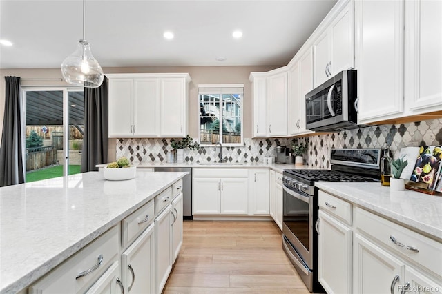 4082 Fortune Ln, Castle Rock, CO 80109 - kitchen featuring stainless steel appliances, white cabinetry, tasteful backsplash, decorative light fixtures, and recessed lighting