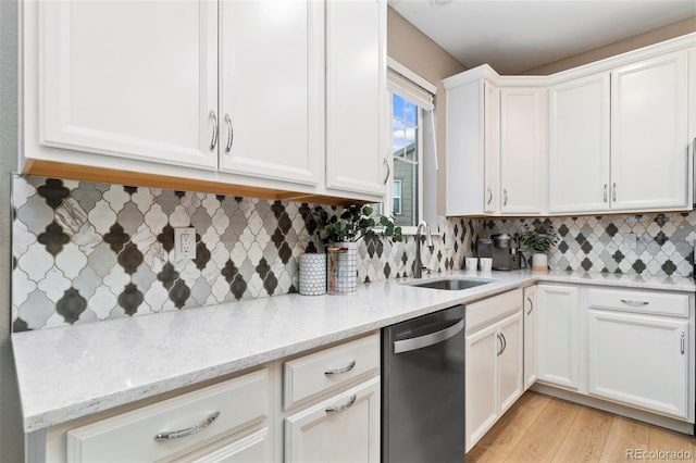 4082 Fortune Ln, Castle Rock, CO 80109 - kitchen with dishwashing machine, white cabinets, light wood-style flooring, light stone countertops, and tasteful backsplash