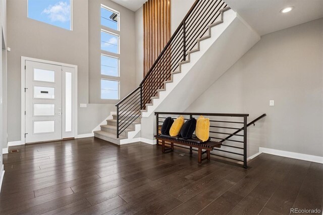 foyer featuring baseboards, stairs, and hardwood / wood-style floors