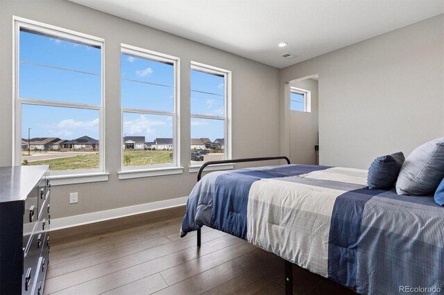 bedroom featuring baseboards, dark wood-style floors, and visible vents