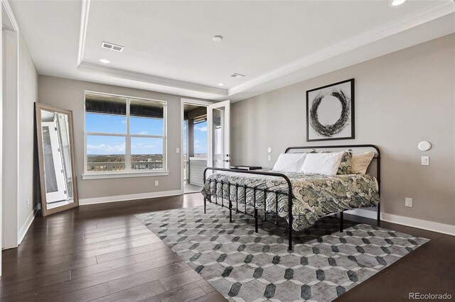 bedroom with visible vents, wood finished floors, a raised ceiling, baseboards, and access to outside