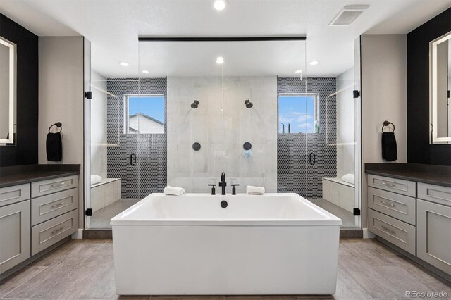 bathroom featuring vanity, wood finished floors, a healthy amount of sunlight, and visible vents