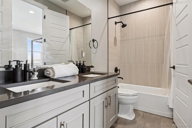 bathroom with double vanity, toilet, shower / bath combination with curtain, and a sink