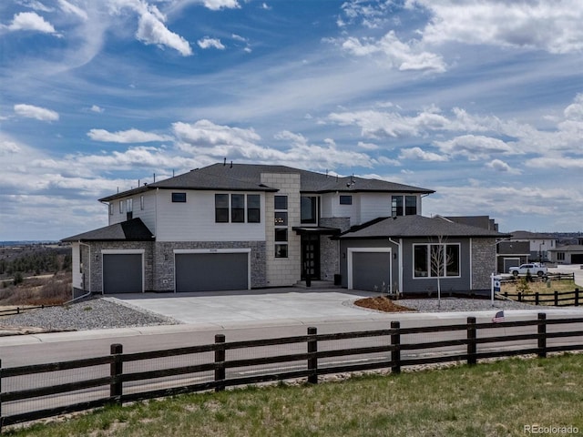 prairie-style house with a garage, fence private yard, and driveway