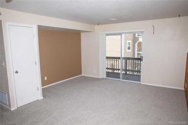 carpeted spare room with baseboards and a textured ceiling