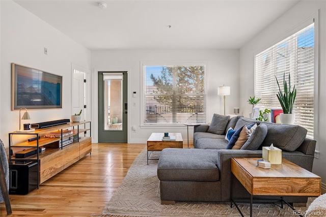 living area with baseboards and light wood-style flooring