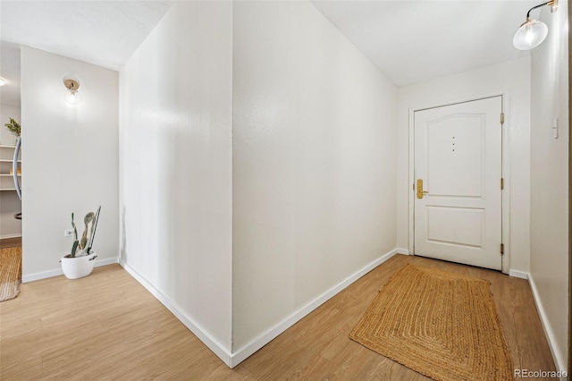 hallway featuring light wood-style floors and baseboards