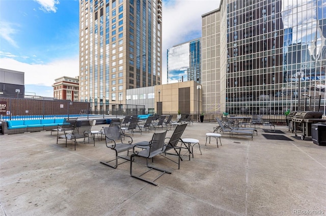 view of patio / terrace with a view of city, area for grilling, and fence