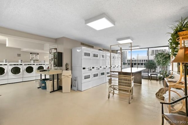 interior space featuring concrete flooring, washer and clothes dryer, stacked washer and clothes dryer, and white cabinets