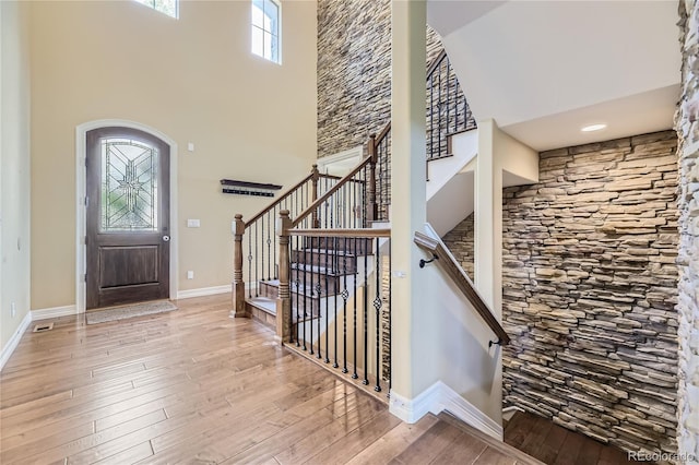 foyer with a towering ceiling and hardwood / wood-style floors