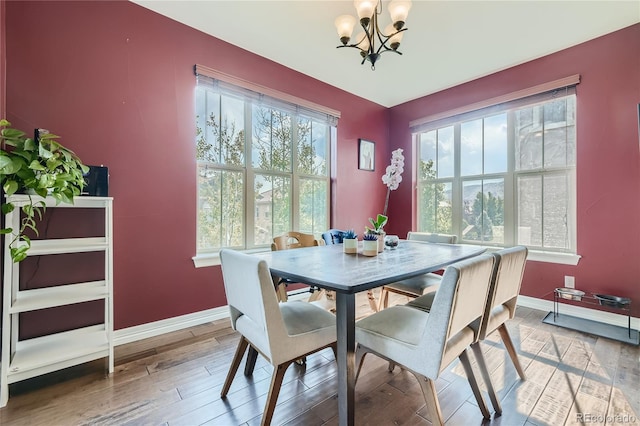 dining space with a chandelier and wood-type flooring