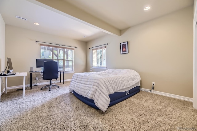 bedroom with beamed ceiling and carpet