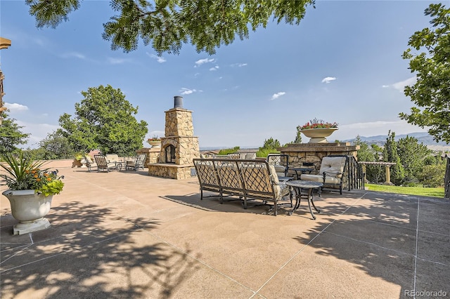 view of patio featuring an outdoor stone fireplace