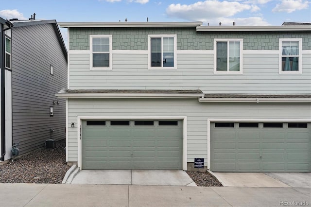 garage with driveway and central air condition unit