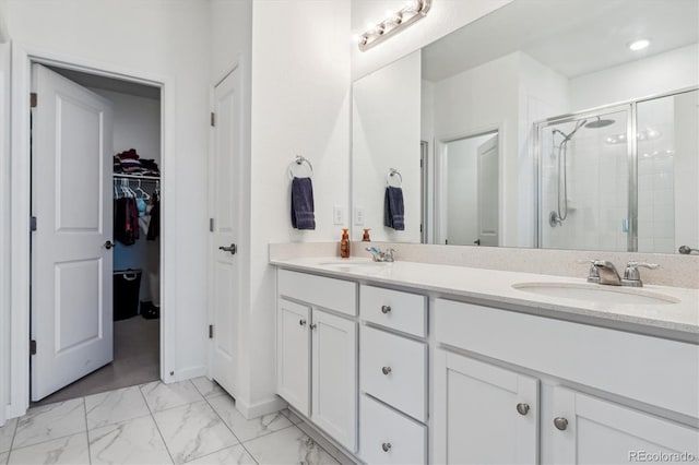 full bathroom featuring a stall shower, marble finish floor, a sink, and double vanity