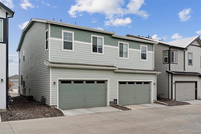 view of front of house featuring a garage, driveway, and central AC